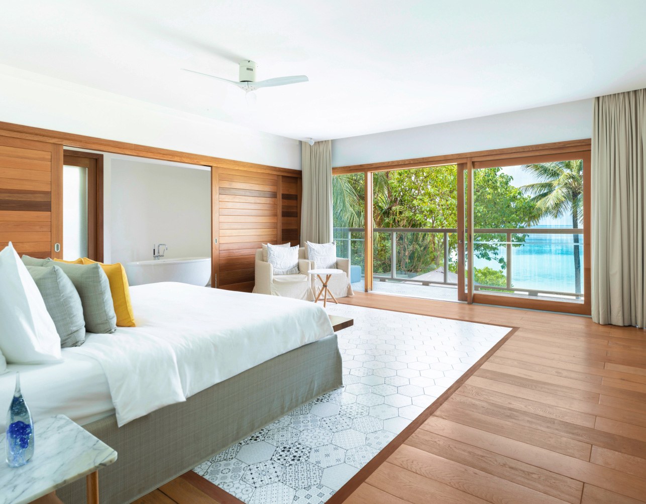 A suite with a king size bed, private balcony, & ensuite bathroom with a soaking tub in our 4 bedroom villa in the Maldives.