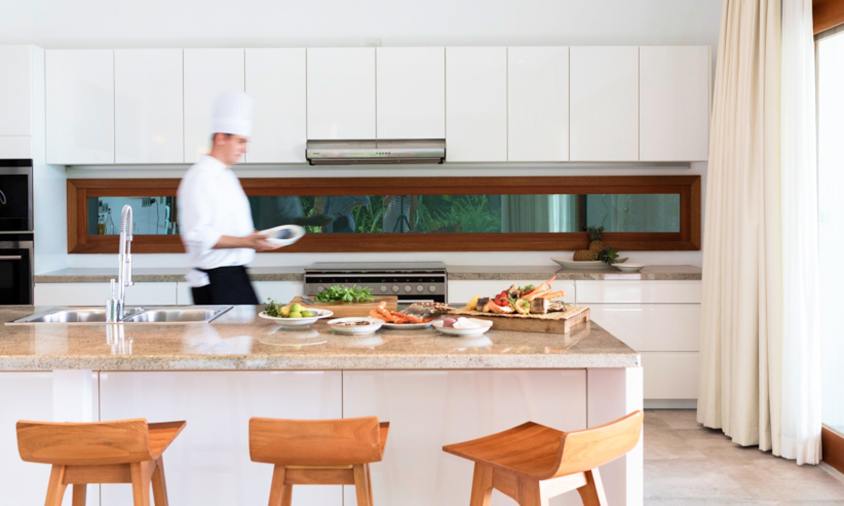 The private chef available on request preparing a meal in the expansive kitchen at our Beach Resort Residences.
