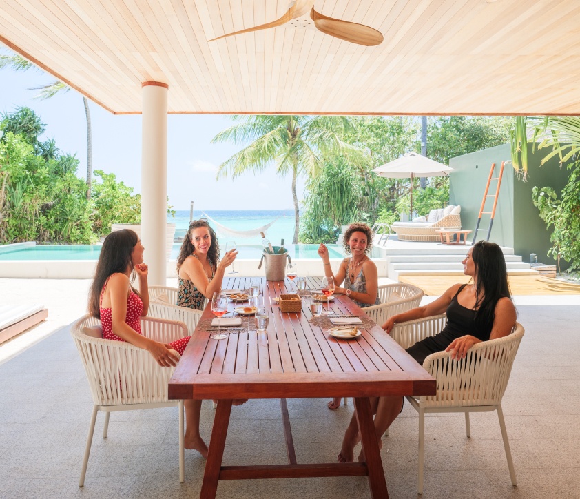 A family enjoying the outdoor covered dining area next to the private freshwater pool at our Beach Resort Residences.