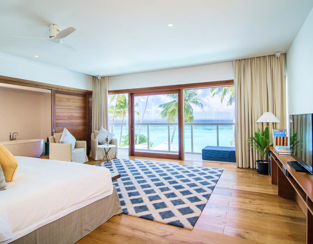 A suite with a king size bed, private balcony, & ensuite bathroom with a soaking tub in our Private Residence in the Maldives
