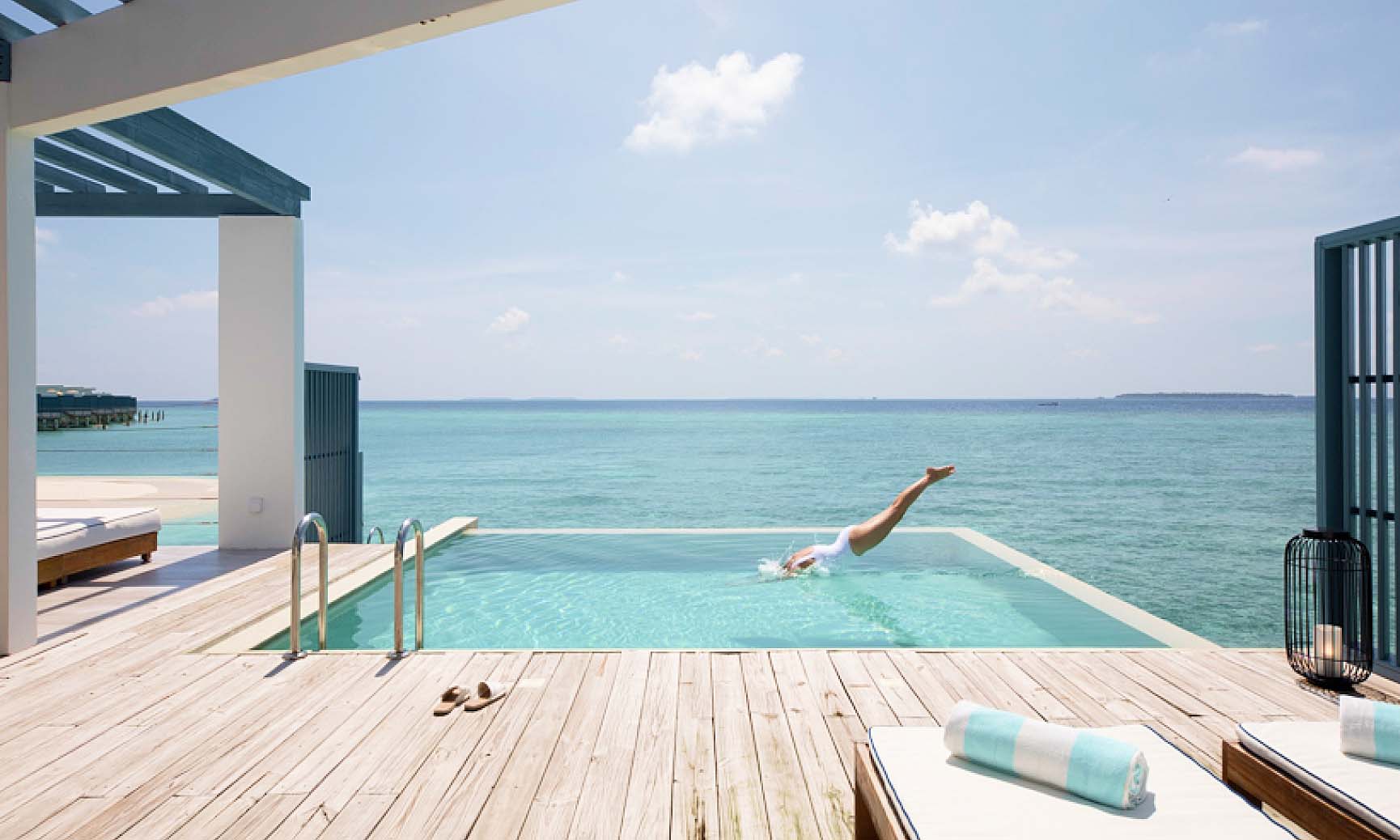 A woman diving into the private freshwater pool on the sundeck of our 1 Bedroom Maldives Lagoon Pool Villa.