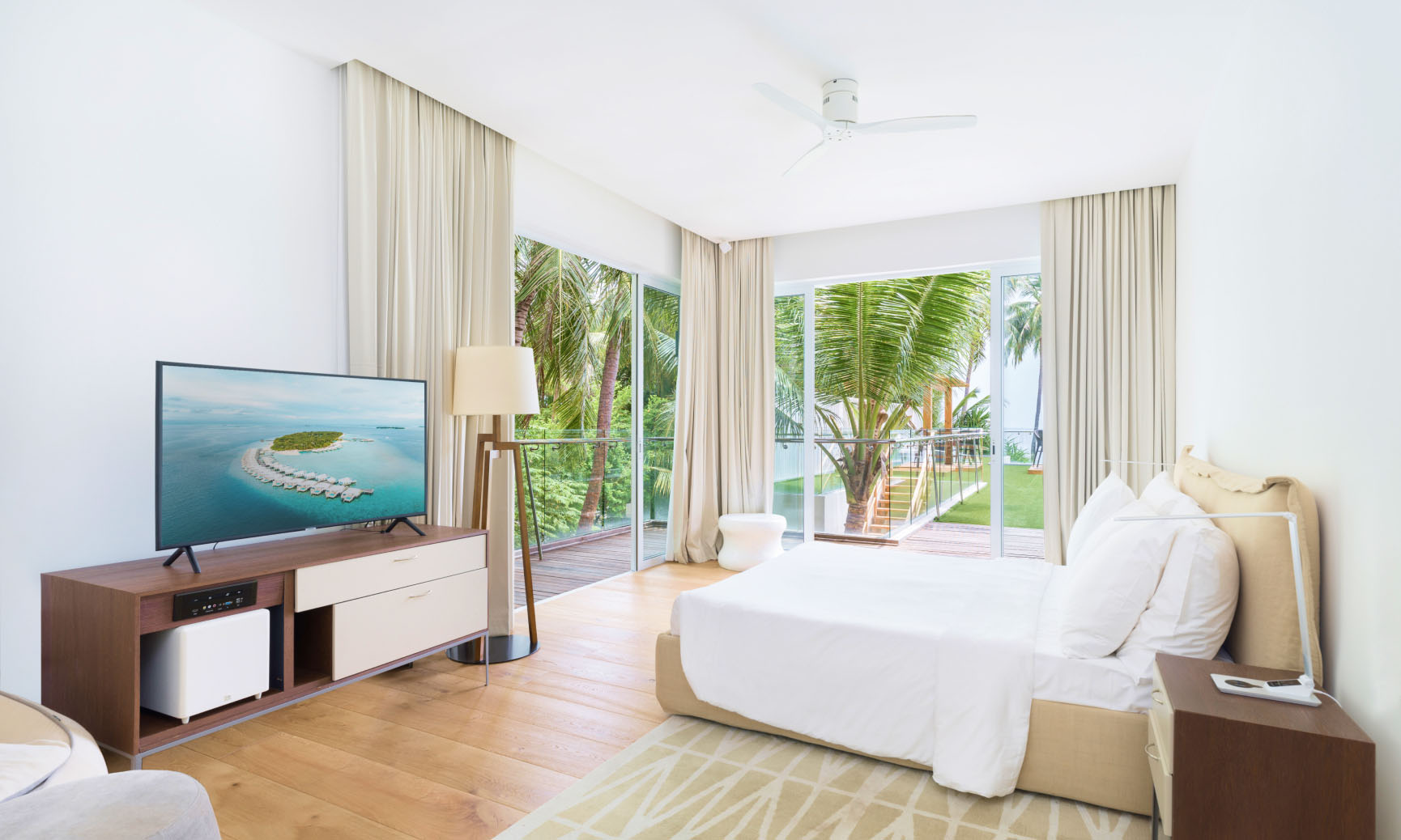 A suite with a king size bed, ensuite bathroom, and floor to ceiling windows at the Amilla Estate, our Maldives Mansion.