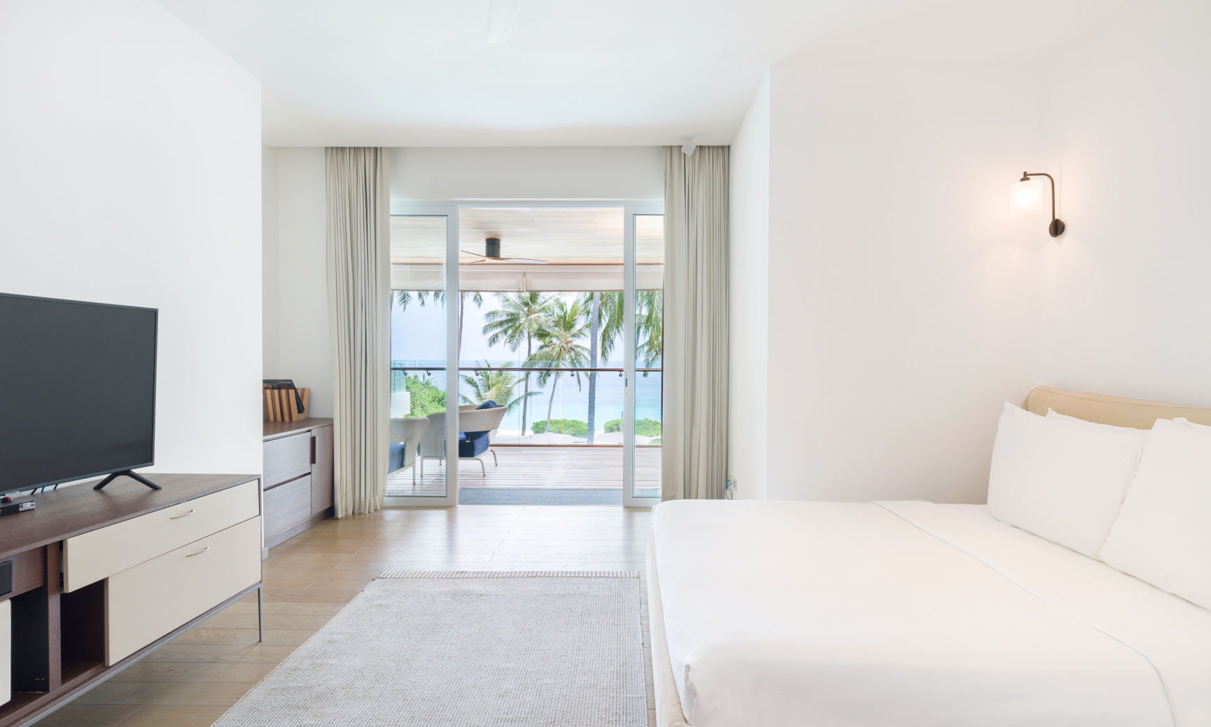 A suite with a king size bed, ensuite bathroom, and private balcony at our Luxury Maldives Family Accommodations.