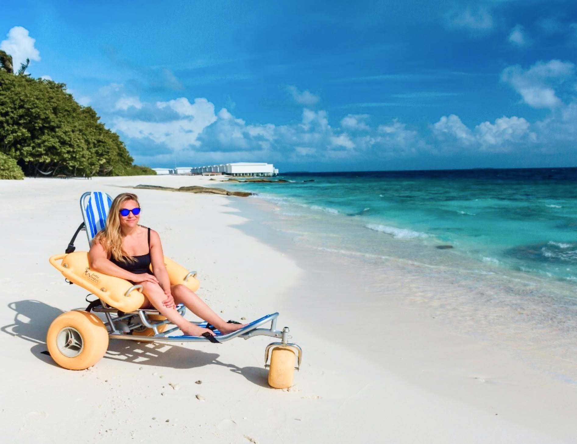 A guest at Amilla Maldives using one of our beach wheelchairs to enjoy paradise.
