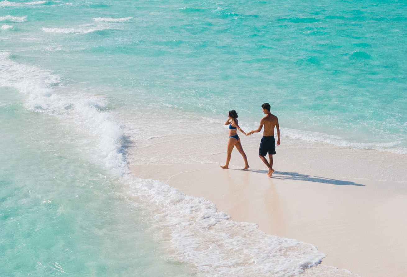 A Couple Enjoying Romantic Sandbank Picnic as part of Amilla Maldives honeymoon offers